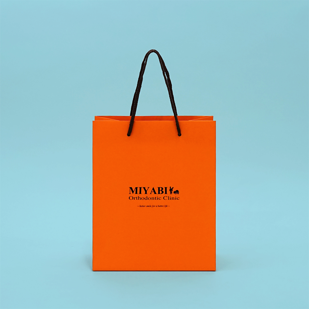 温かみのあるオレンジにエンボス加工で質感もこだわった歯科医院の紙袋0