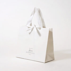 シンプルなホワイトベースに、口留め加工を施すことでギフト感を演出したオリジナル紙袋