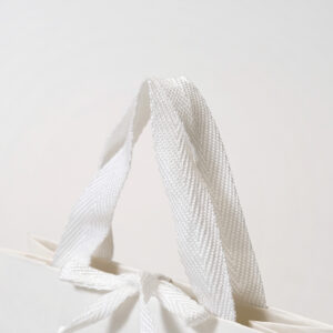 アクリル平紐をハンドルに採用した、ユニセックスで使いやすい素材にこだわったオリジナル紙袋