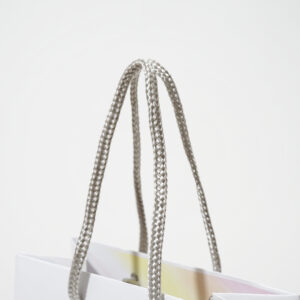 シンプルなホワイトに、口折り部分のレインボーカラーが華やかなアクセントとなるオリジナル紙袋