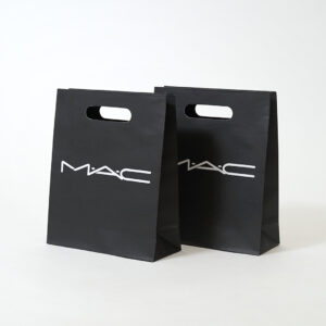 内面に蛍光イエロー色が印刷され、口折り部分にブランドのURLがプリントされた、有名コスメブランドのオリジナル紙袋