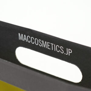 内面に蛍光イエロー色が印刷され、口折り部分にブランドのURLがプリントされた、有名コスメブランドのオリジナル紙袋