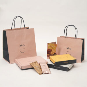 晒クラフト紙の風合いと全面印刷されたピンクがマッチした、バターゴーフレット専門店の統一感あふれるオリジナル紙袋とオリジナルボックス