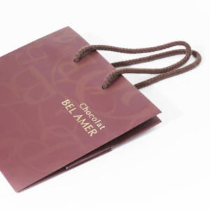 エンボス加工が施された表面が高級感を醸し出す、人気チョコレートブランドの洗練されたオリジナル紙袋