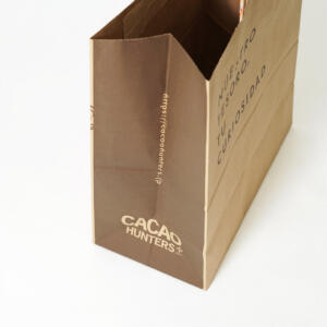 チョコレードブランドのベタ塗りのサイドに、ロゴとURLが印刷された、クラフト紙素材のオリジナル紙袋