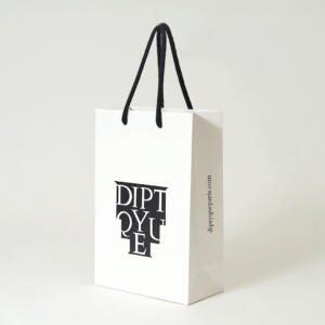 黒のアクリルスピンドルを使用したモノトーンのデザインがエレガントなフレグランスブランドのオリジナル紙袋