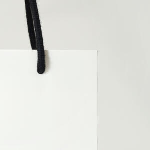 黒のアクリルスピンドルを使用したモノトーンのデザインがエレガントなフレグランスブランドのオリジナル紙袋