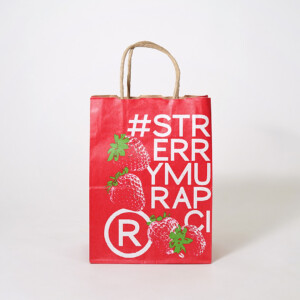 いちごのイラストと商品のハッシュタグをフルカラー印刷で大胆に描いた、超有名コーヒーショップのクラフト素材のオリジナル紙袋