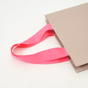 細かいエンボス加工が高級感を演出する、有名コスメブランドの配色が印象的なオリジナル紙袋