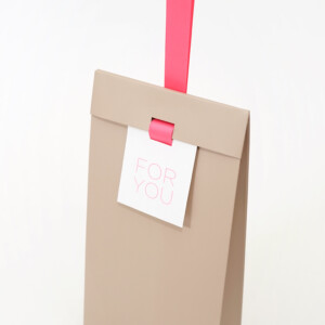 ピンクのワンハンドル仕様で手渡しに最適な、有名コスメブランドのオリジナルプレゼントバッグ