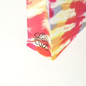 ロゴに浮き出し加工を施し、ワックスコードハンドルを使用した高級ファッションブランドの華やかなオリジナル紙袋