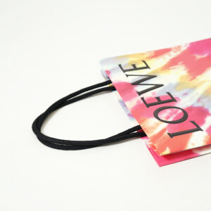 ロゴに浮き出し加工を施し、ワックスコードハンドルを使用した高級ファッションブランドの華やかなオリジナル紙袋