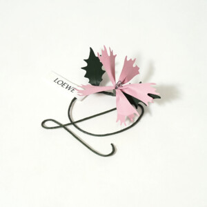 高級ファッションブランドの、ブランドシンボルを模した飾りが付いたアクセサリー