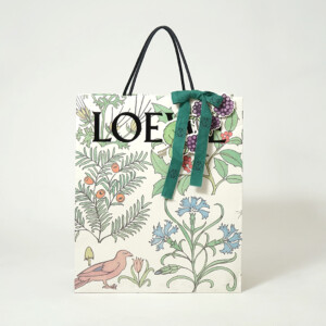 ロゴに浮き出し加工を施し、ワックスコードハンドルを使用した高級ファッションブランドのホリデーシーズン限定オリジナル紙袋