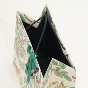 ロゴに浮き出し加工を施し、ワックスコードハンドルを使用した高級ファッションブランドのホリデーシーズン限定オリジナル紙袋