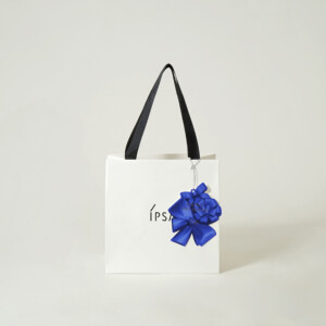 コスメブランドの鮮やかな青色チャームに、シルバーの箔押し加工が施された、ホリデー限定オリジナル紙袋