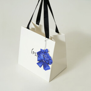 コスメブランドの鮮やかな青色チャームに、シルバーの箔押し加工が施された、ホリデー限定オリジナル紙袋