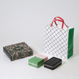 人気洋菓子店が手掛ける、ボタニカル柄が華やかなオリジナルボックスと晒クラフト紙に網目状のパターンを印刷した、レトロモダンなオリジナル紙袋