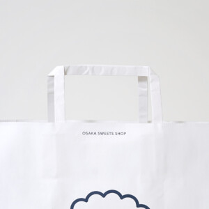 スイーツブランドの藍色の縁取りが上品な、世界観を伝える紙製ハンドルを採用したオリジナル紙袋