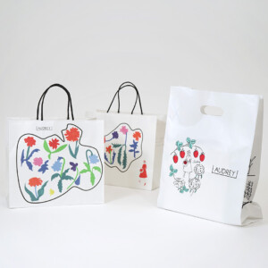 人気スイーツブランドのレトロポップなイラストをフルカラー印刷で表現した、オリジナル紙袋とブランドのシンボルである、赤いワンピースの女の子が描かれたオリジナルポリ袋