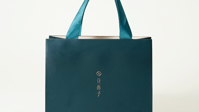 トレンドカラーを取り入れたコスメブランドの凛とした紙袋を読む