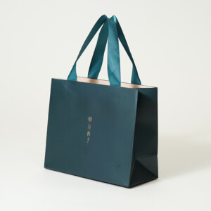 ピーコックグリーンと箔押し加工が美しい、高級感のあるコスメブランドのオリジナル紙袋