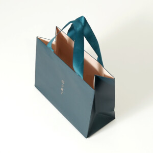 ピーコックグリーンと箔押し加工が美しい、高級感のあるコスメブランドのオリジナル紙袋