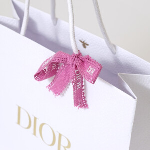 有名コスメブランドの純白ボディに映える、高級感のある箔押しロゴとピンクリボンが可愛いオリジナル紙袋