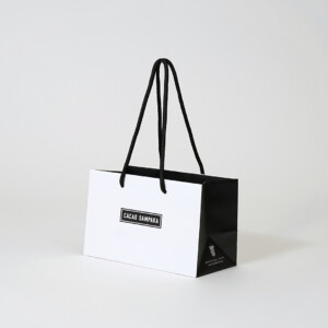 マチ部分にブランドURLを印刷した、スペイン王室御用達のチョコレートブランドによる、モノトーンでシックなオリジナル紙袋