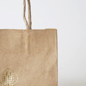 大阪・天神橋の台湾菓子専門店が手がけた、クラフト紙に箔押しとエンボス加工を施し、温かみと高級感を両立させたオリジナル紙袋