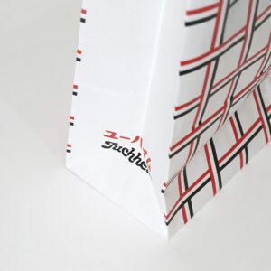 有名洋菓子ブランドのチェック柄が目を惹く、ハンドルも含め全て紙製のサステナブルなオリジナル紙袋