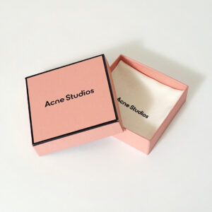 コーラルピンクを全面印刷で表現し、黒フチデザインがスタイリッシュな有名ファッションブランドのリニューアルしたオリジナルボックス