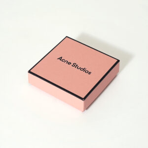 コーラルピンクを全面印刷で表現し、黒フチデザインがスタイリッシュな有名ファッションブランドのリニューアルしたオリジナルボックス