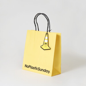 韓国発、プラスチックアップサイクリングブランドのポップなイエローと紙製ハンドルが映えるオリジナル紙袋
