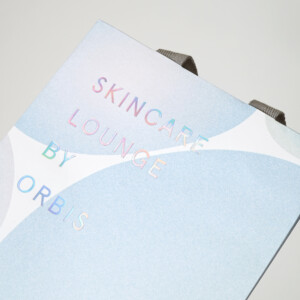 化粧品ブランドが手がけた、体験特化型施設の光の反射でオーロラのように輝くレインボー箔が美しいオリジナル紙袋