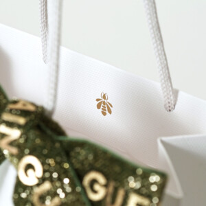 ラグジュアリーコスメブランドのハニカム柄のエンボス加工とブランドロゴに浮き出し箔が施された、ゴージャスで美しいオリジナル紙袋