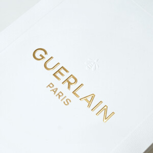 ラグジュアリーコスメブランドのハニカム柄のエンボス加工とブランドロゴに浮き出し箔が施された、ゴージャスで美しいオリジナル紙袋