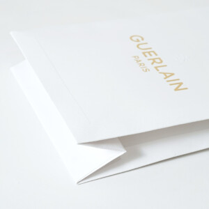 ラグジュアリーコスメブランドのハニカム柄のエンボス加工とブランドロゴに浮き出し箔が施された、ゴージャスで美しいオリジナル紙袋