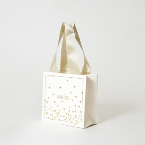 マットPP加工を施したボディに箔押し加工でドット模様とロゴを印字した、コスメブランドの高級感あふれるオリジナル紙袋