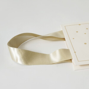 マットPP加工を施したボディに箔押し加工でドット模様とロゴを印字した、コスメブランドの高級感あふれるオリジナル紙袋