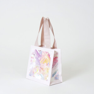 華やかな彩りの本体にホワイトの箔押しを施した、オーガニックコスメブランドのアニバーサリー限定オリジナル紙袋