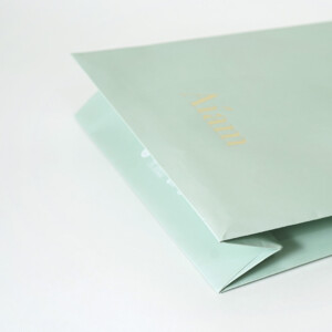V字折り底とゴールドの箔押し加工を施した、鮮やかなミントグリーン色のフレグランスブランドのオリジナル紙袋