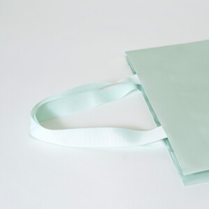 V字折り底とゴールドの箔押し加工を施した、鮮やかなミントグリーン色のフレグランスブランドのオリジナル紙袋