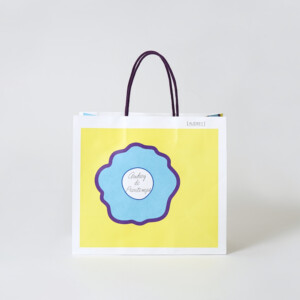 ハンドルに芯入りのアクリルスピンドルを使用した、バレンタイン限定の華やかな花柄デザインが目を引く東京人気土産ブランドのオリジナル紙袋