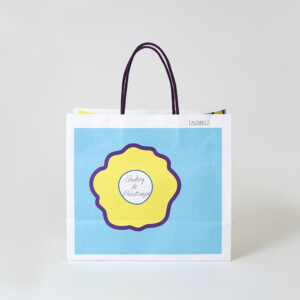 ハンドルに芯入りのアクリルスピンドルを使用した、バレンタイン限定の華やかな花柄デザインが目を引く東京人気土産ブランドのオリジナル紙袋