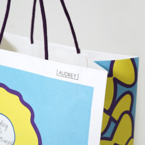 ハンドルに芯入りのアクリルスピンドルを使用した、バレンタイン限定の華やかな花柄デザインが目を引く東京人気土産ブランドのオリジナル紙袋