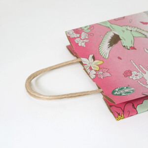 フレキソ印刷を用いて春らしい景色を描いた、コーヒーショップの桜色のオリジナル紙袋