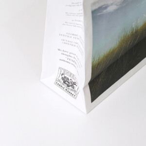 広大な草原がフルカラー印刷された、ファブリックブランドのオリジナル紙袋