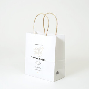 クラフトのような優しい風合いの用紙に、紙丸紐のハンドルを使用した、キャラメル×チョコレート専門ブランドのオリジナル紙袋