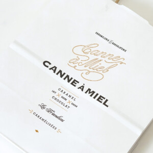 クラフトのような優しい風合いの用紙に、紙丸紐のハンドルを使用した、キャラメル×チョコレート専門ブランドのオリジナル紙袋